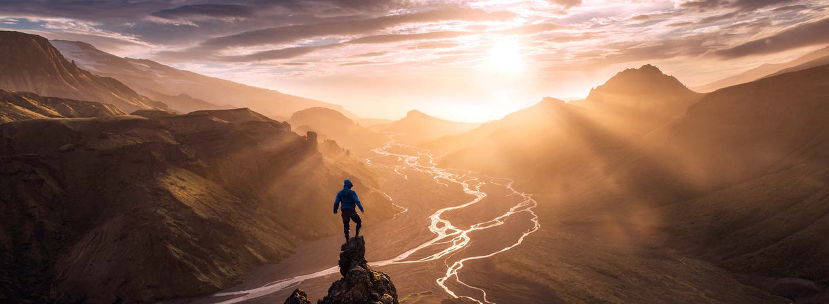 Photographer overlooking a mountain valley at sunset