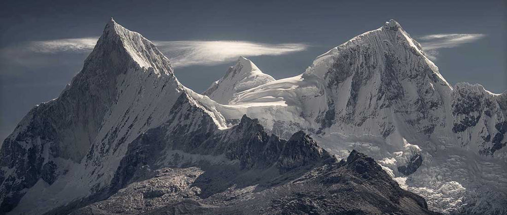 a panorama of the mountain range of cordillera huayhuash in the Peru with sunrise light and lenticular clouds.