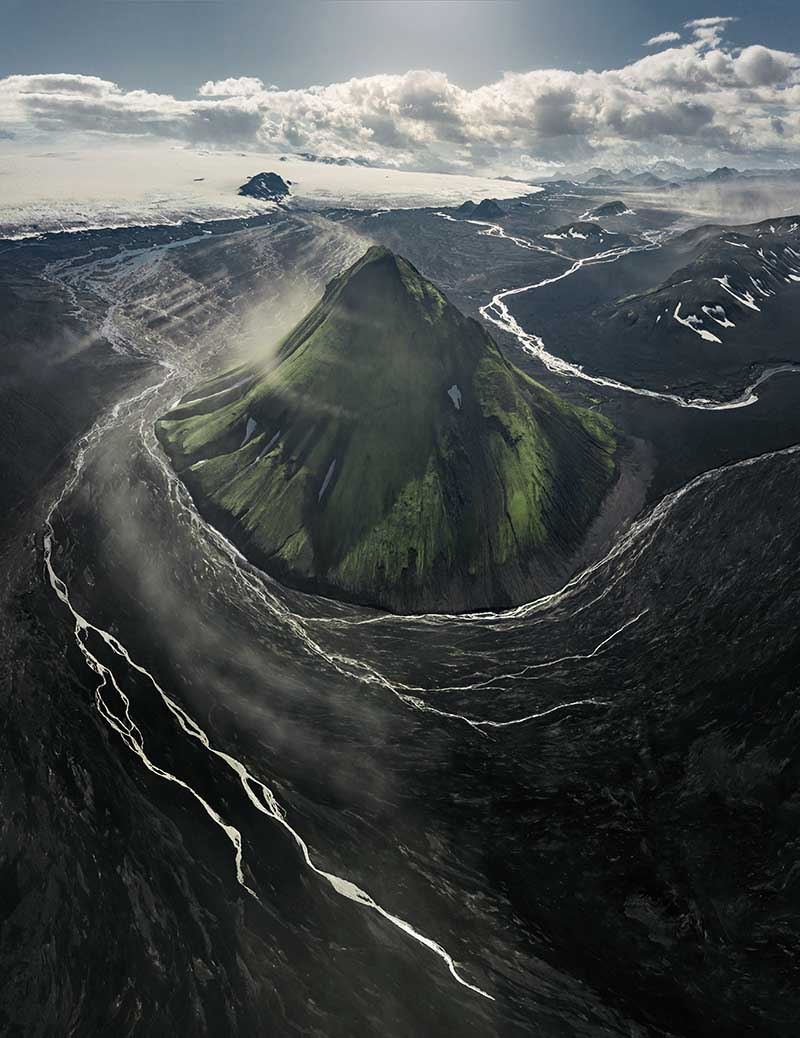 Maelifell glacier in Iceland as seen from drone perspective. glacier rivers bend their way around the cone shaped mountain peaks.