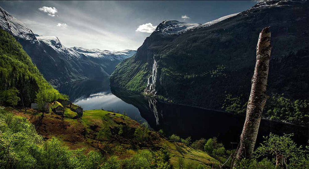 seven sisters waterfall in Norway as seen from a high view point with a skageflå farm on the cliffside.