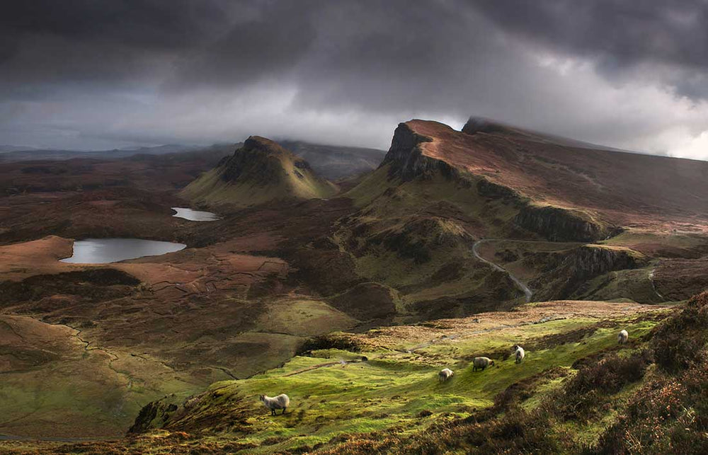 Quiraing mountains in Scotland with stormy sunset light and sky.