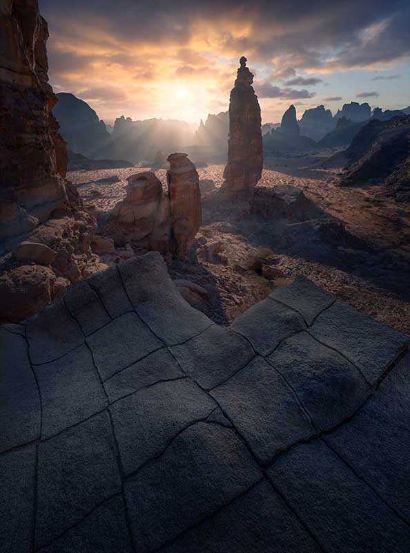 a sunrise in Wadi Al Disah in Saudi Arabia showcasing intricate rock details and mountain layer formations.