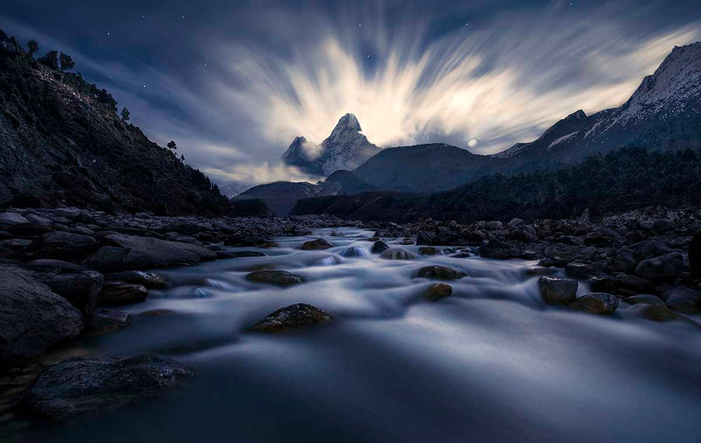 Ama Dablam in Nepal during moonrise. The stream below flows towards the mountains. 