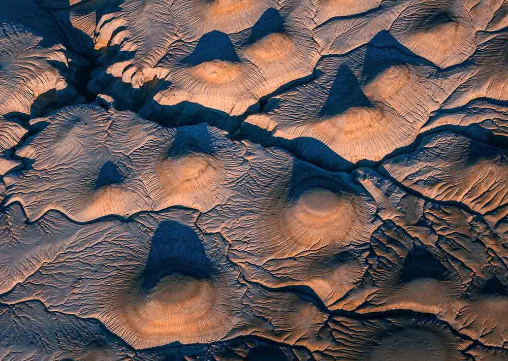 Round brown rock formations form abstracts by drone in Kazakhstan at sunrise.
