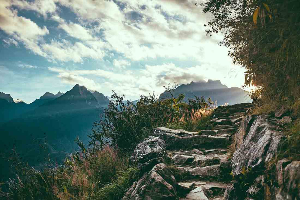 salkantay stone stairs leading to a corner with mountains in the background.
