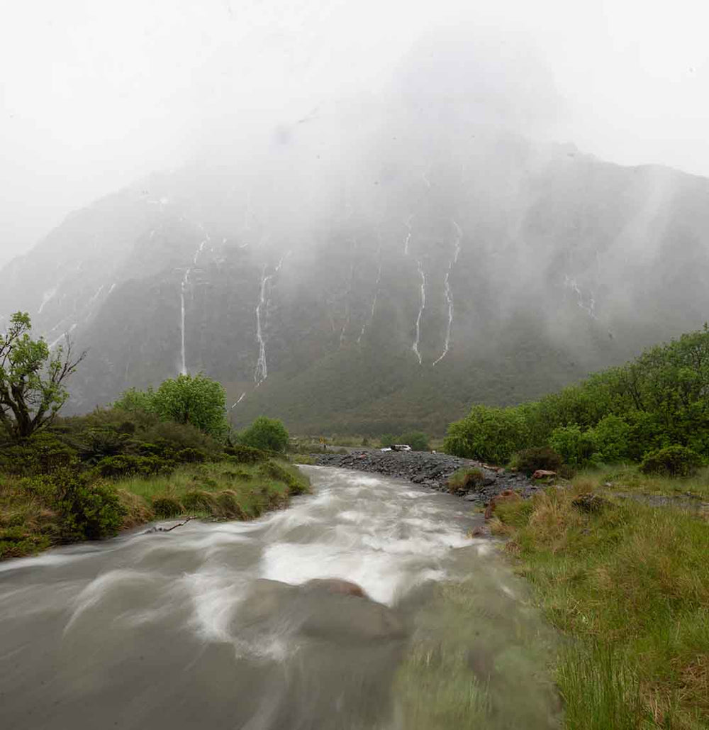 an overexposed raw file of waterfalls and a stream in milford sound new Zealand.