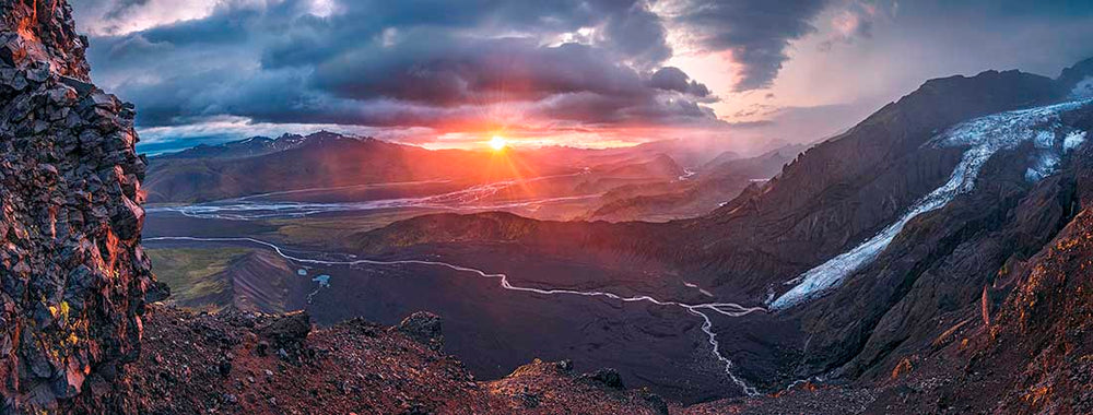 A panorama of a glacier in thormsork during a red sunset.