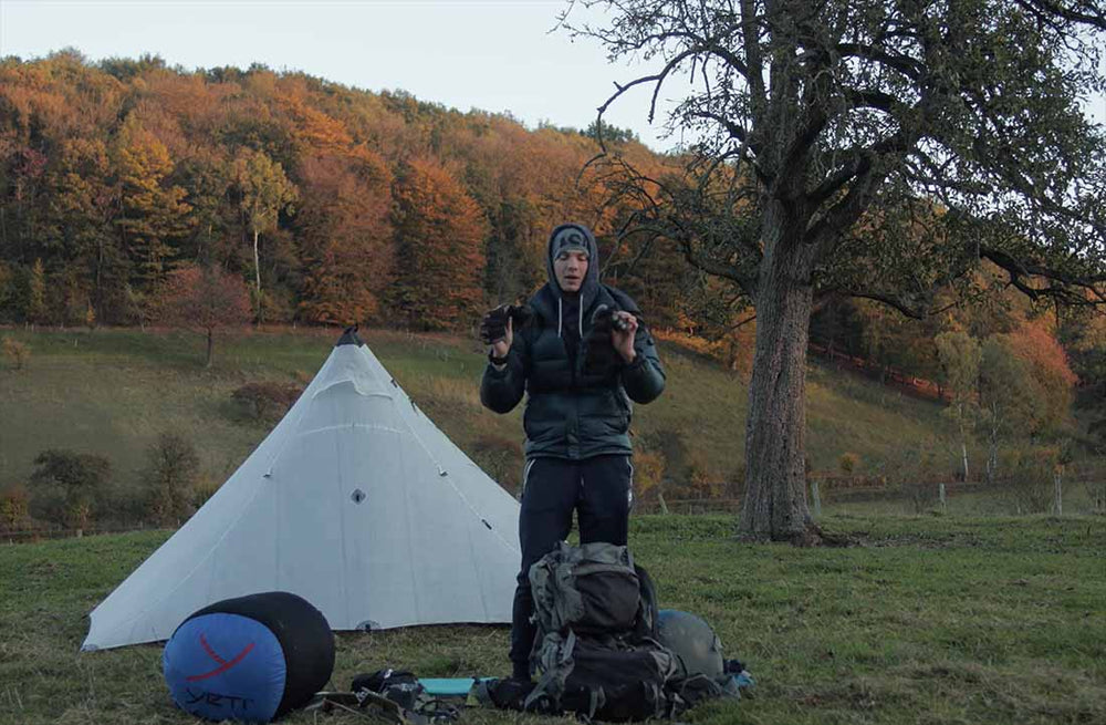 max rive showing his camping gear and equipment next to his tent.