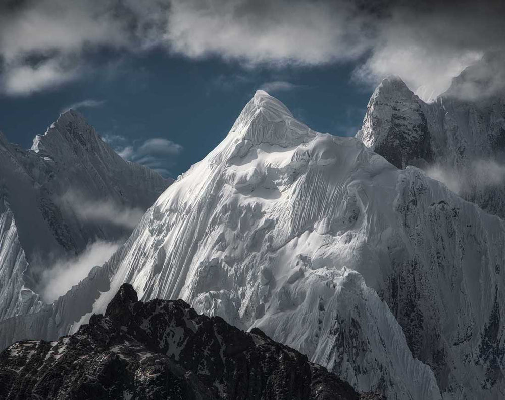 The giant snow covered mountains of cordillera huayhuash in Peru as seen from a high vantage point. Taken in summer.