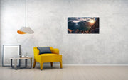 hanged canvas print in room with yellow chair of Person looking towards the setting sun in Greenalnd with an ice-filled fjord down below 