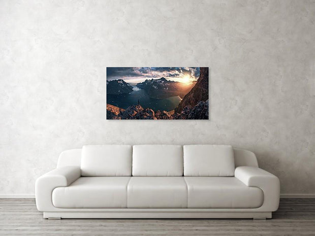hanged canvas print of Person looking towards the setting sun in Greenalnd with an ice-filled fjord down below 