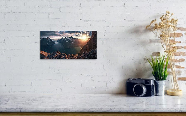 small hanged canvas print of Person looking towards the setting sun in Greenalnd with an ice-filled fjord down below 