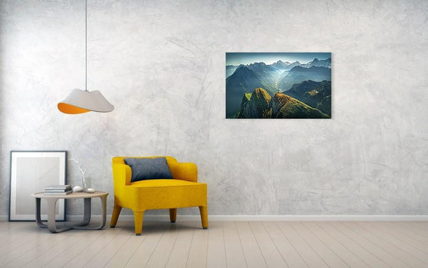 Print hanged in living room of landscape of green mountains in swiss alps with snow-capped mountains in the back