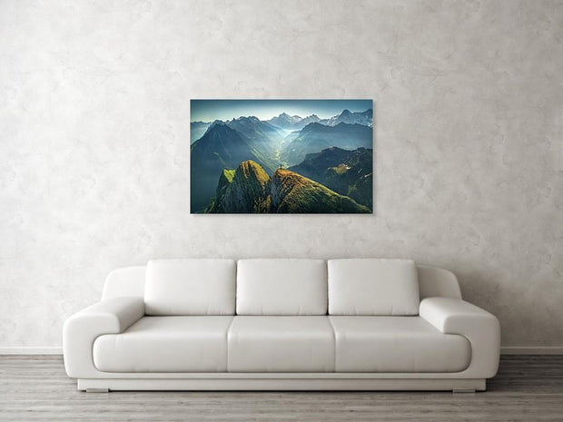 Print hanged on wall of landscape of green mountains in swiss alps with snow-capped mountains in the back