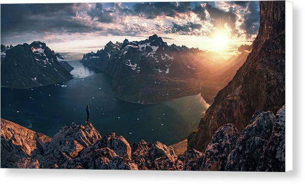 canvas print mockup with white sides of Person looking towards the setting sun in Greenalnd with an ice-filled fjord down below 
