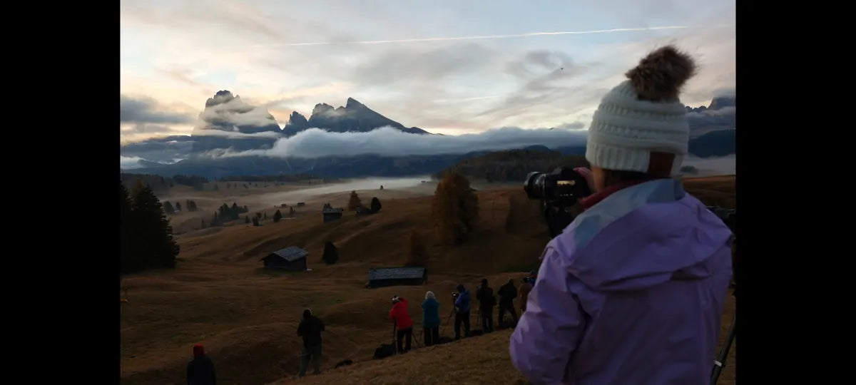 Photographers overlooking a misty valley in the Dolomites