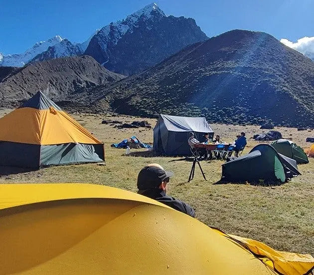 Tents and a seated photographer at a mountain camp in Peru