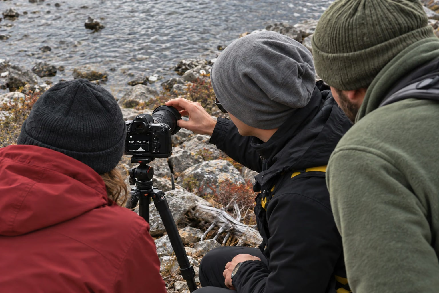 An instructor explaining camera settings to a small group beside a Patagonian lake