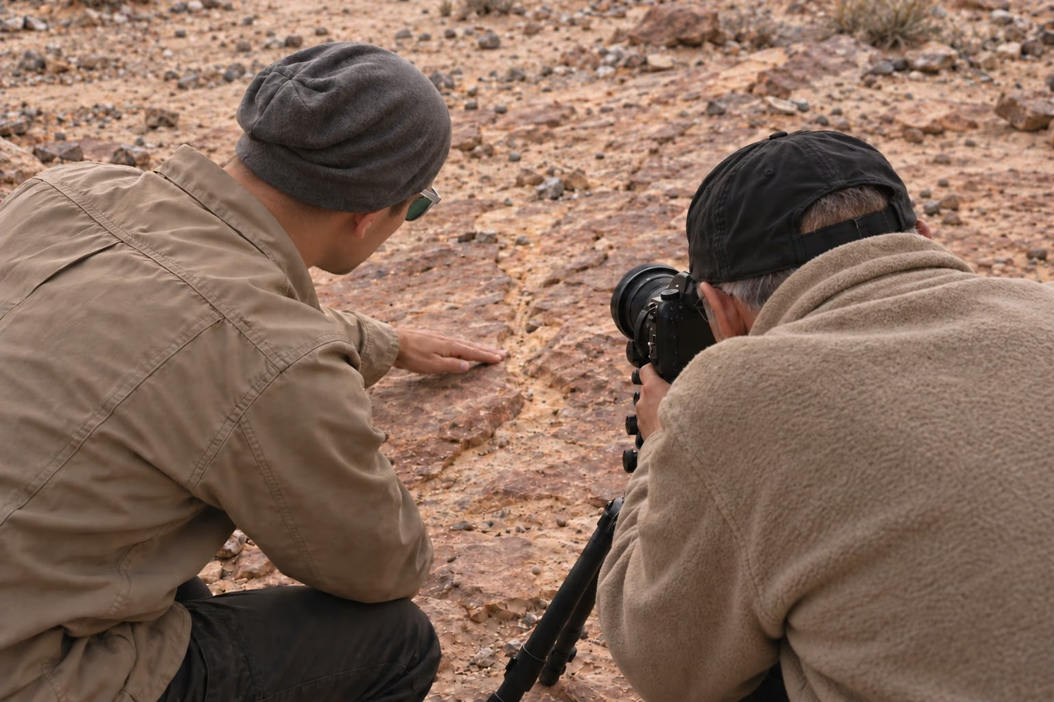 An instructor helping a photographer compose a close-up scene on desert sandstone