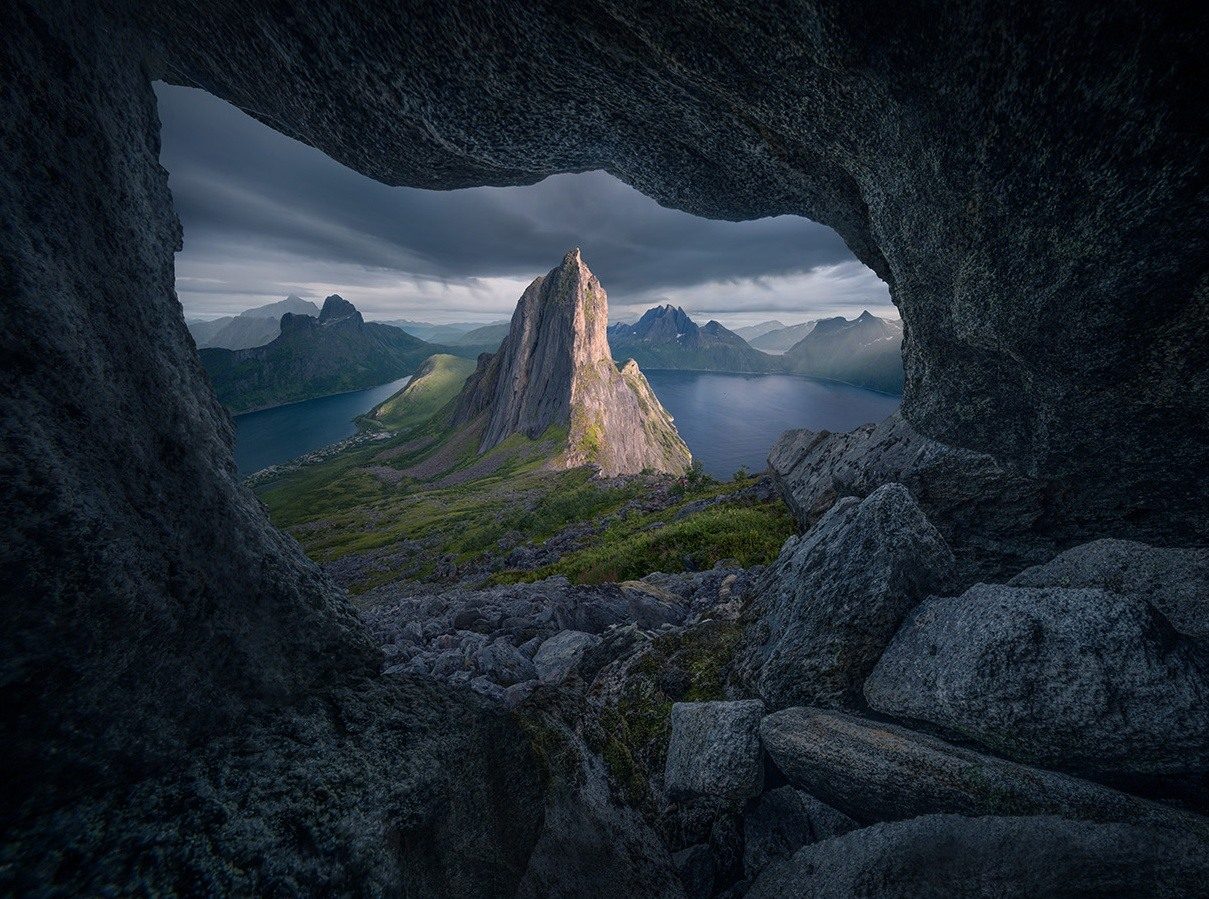 Segla and a fjord framed by an opening between dark boulders on Senja.